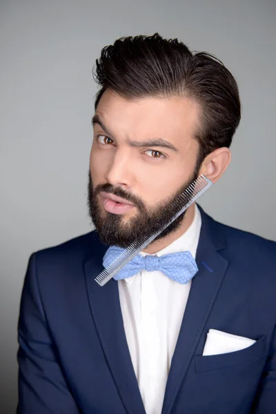 Handsome man with beard and comb in it