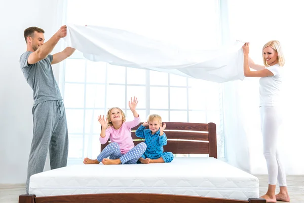 Young nice family making bed