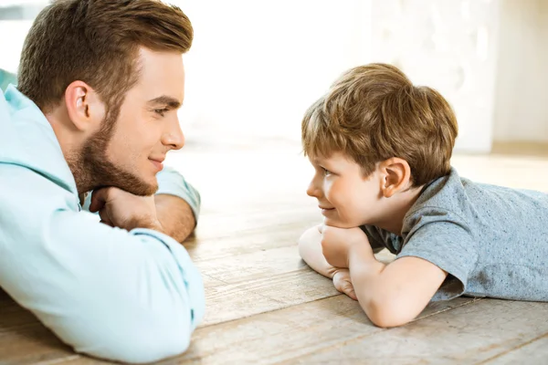 Little boy and his father on wooden floor