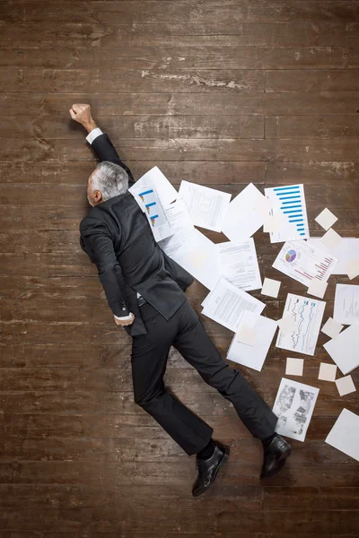 Top view photo of senior businessman on wooden floor