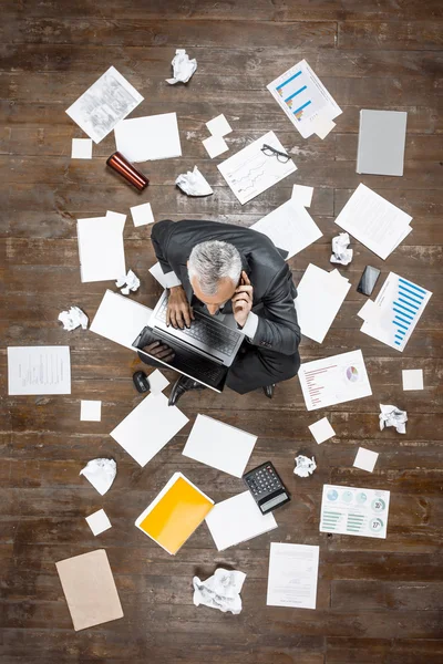 Top view photo of senior businessman on wooden floor