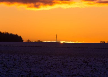Güzel, parlak, renkli bir kış gündoğumu manzarası. Parlak gökyüzü ve ilk kar. Güneş doğarken Kuzey Avrupa 'nın kış manzarası.