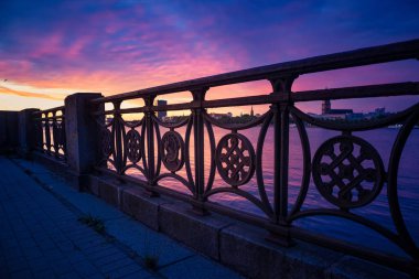 Şehrin ortasındaki nehirde güzel bir gün batımı manzarası. Riga, Letonya 'da akşam manzarası. Şehir ve nehir üzerinde günbatımı renkleri.