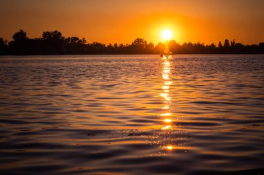 Riga, Letonya 'da nehrin üzerinde güzel bir günbatımı. Nehirde bir yaz akşamı.