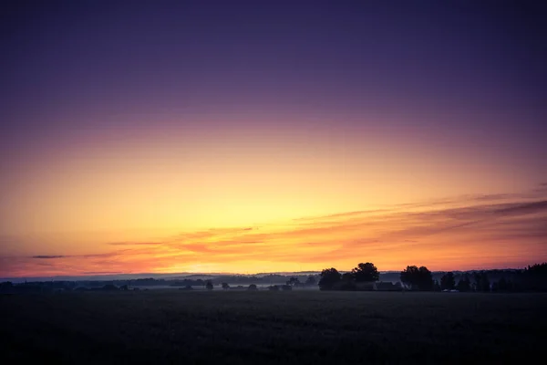 A minimalist landscape of a misty sunrise in summer with a far horizon. Summertime scenery of Northern Europe.