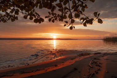 Güneşin doğuşundan hemen sonra güzel bir sonbahar manzarası. Titrek gökyüzü yansımaları ir Riga, Letonya.