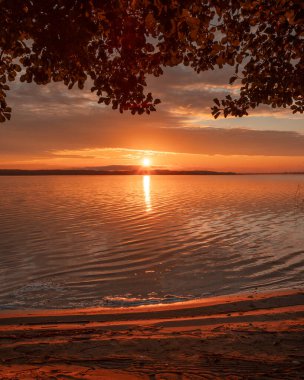 Güneşin doğuşundan hemen sonra güzel bir sonbahar manzarası. Titrek gökyüzü yansımaları ir Riga, Letonya.
