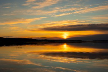 Güneşin doğuşundan hemen sonra güzel bir sonbahar manzarası. Titrek gökyüzü yansımaları ir Riga, Letonya.