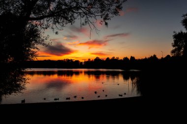 Gölde, renkli gökyüzü ile güzel bir sonbahar güneşi. Riga, Letonya 'nın akşam manzarası.