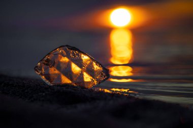 Baltık Denizi sahilinde gün batımını yansıtan güzel bir cam parçası. Letonya, Avrupa 'da sanatsal akşam manzarası.