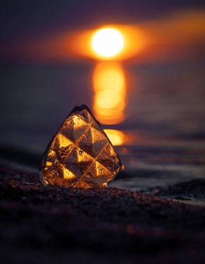 Baltık Denizi sahilinde gün batımını yansıtan güzel bir cam parçası. Letonya, Avrupa 'da sanatsal akşam manzarası.