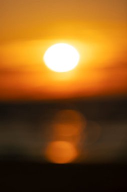 Baltık Denizi 'nin dalgalarına yansıyan batan bir güneşin odak günbatımı görüntüsü. Renkli bokeh.