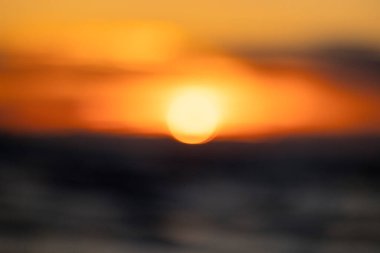 Baltık Denizi 'nin dalgalarına yansıyan batan bir güneşin odak günbatımı görüntüsü. Renkli bokeh.