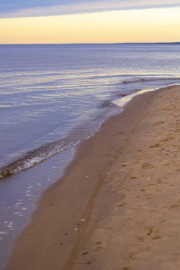 Gün batımındaki deniz dalgalarının soyut ve minimalist bir resmi. Sığ alan derinliği, Bokeh, yakın hasat. Letonya, Avrupa 'da yaz akşamı. Baltık Denizi kıyısı.