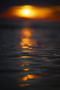 Gün batımındaki deniz dalgalarının soyut ve minimalist bir resmi. Sığ alan derinliği, Bokeh, yakın hasat. Letonya, Avrupa 'da yaz akşamı. Baltık Denizi kıyısı.