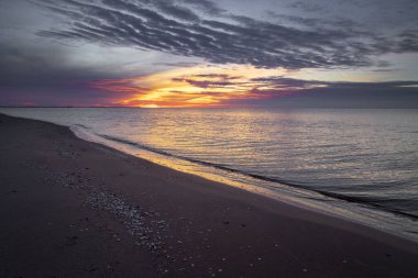 Baltık Denizi kıyılarında güzel bir yaz gün batımı manzarası. Letonya, Avrupa 'da gün batımından sonra renkli gökyüzü.