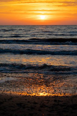 Baltık Denizi üzerinde güzel, renkli bir yaz günbatımı. Letonya, Avrupa 'daki plajda yaz akşamı.