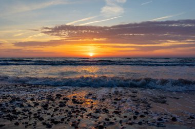 Baltık Denizi üzerinde güzel, renkli bir yaz günbatımı. Letonya, Avrupa 'daki plajda yaz akşamı.