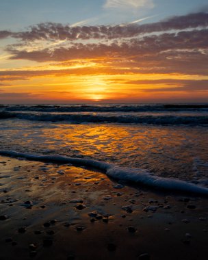 Gün batımındaki deniz dalgalarının soyut ve minimalist bir resmi. Sığ alan derinliği, Bokeh, yakın hasat. Letonya, Avrupa 'da yaz akşamı. Baltık Denizi kıyısı.