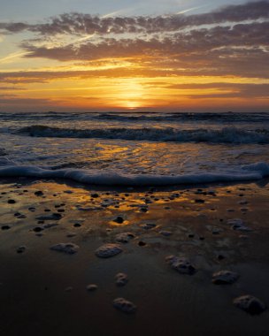 Gün batımındaki deniz dalgalarının soyut ve minimalist bir resmi. Sığ alan derinliği, Bokeh, yakın hasat. Letonya, Avrupa 'da yaz akşamı. Baltık Denizi kıyısı.