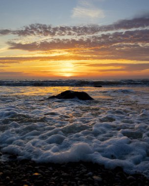 Gün batımındaki deniz dalgalarının soyut ve minimalist bir resmi. Sığ alan derinliği, Bokeh, yakın hasat. Letonya, Avrupa 'da yaz akşamı. Baltık Denizi kıyısı.