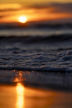 Gün batımındaki deniz dalgalarının soyut ve minimalist bir resmi. Sığ alan derinliği, Bokeh, yakın hasat. Letonya, Avrupa 'da yaz akşamı. Baltık Denizi kıyısı.