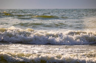 Baltık Denizi sahiline vuran güzel bir güneş ışığı dalgası. Letonya, Avrupa 'da güneşli bir yaz günü.
