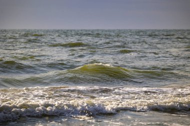 Baltık Denizi sahiline vuran güzel bir güneş ışığı dalgası. Letonya, Avrupa 'da güneşli bir yaz günü.