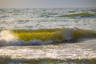 Baltık Denizi sahiline vuran güzel bir güneş ışığı dalgası. Letonya, Avrupa 'da güneşli bir yaz günü.
