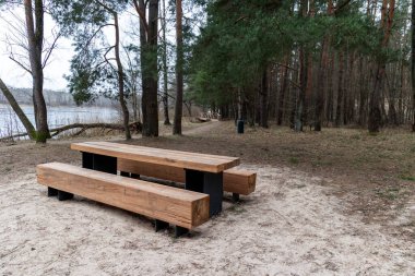 Şehirdeki bir gölün kıyısında küçük bir dinlenme alanı. Letonya, Avrupa 'da ilkbahar manzarası.