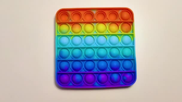 Anti-Stress-Spielzeug macht 's möglich. Rainbow Touch zappelt auf hellem Hintergrund. Neues modisches Silikonspielzeug — Stockvideo