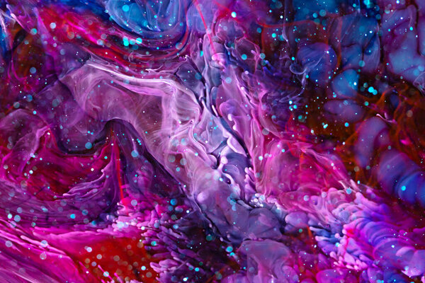 Epoxy resin texture with pink, blue and red colors. Liquid backdrop with splashes and ripples. Modern abstract artwork with splatter inks. Bright colors mixes on macrophotography wallpaper.