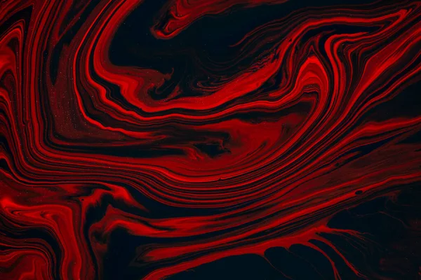 Fluid art texture. Abstract backdrop with mixing paint effect. Liquid acrylic picture that flows and splashes. Mixed paints for posters or wallpapers. Black, red and orange overflowing colors.