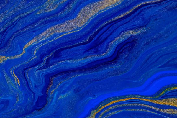 Fluid art texture. Background with abstract iridescent paint effect. Liquid acrylic picture with flows and splashes. Classic blue color of the year 2020. Blue, golden and indigo overflowing colors.