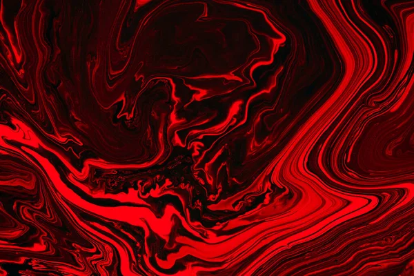 Fluid art texture. Backdrop with abstract swirling paint effect. Liquid acrylic picture that flows and splashes. Mixed paints for posters or wallpapers. Orange, red and black overflowing colors.