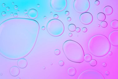 Damlaları olan yaratıcı neon fon. Kabarcıklar üzerinde canlı gradyanlarla parlayan soyut arkaplan. Mavi ve pembe taşan renkler