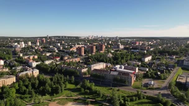 Slunečný den, městský let. Malý městský letecký výhled s auty, domy a jasnou modrou oblohou. Barevné panorama s krásnými slunečními paprsky a střechami města. Létání nad silnicemi a bytovými domy. — Stock video