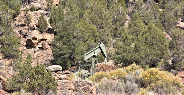 Oil rig pumping oil out of he rocky desert landscape