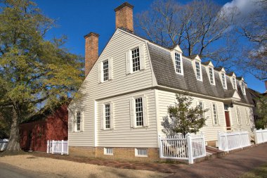 Beyaz çitlerle çevrili bir koloni evi.