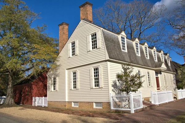 Beyaz çitlerle çevrili bir koloni evi.