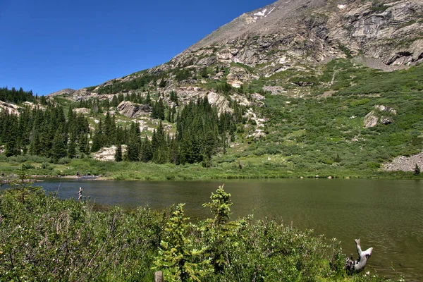 高山湖中的冷水是遥远背景中鳟鱼渔民的最爱 — 图库照片