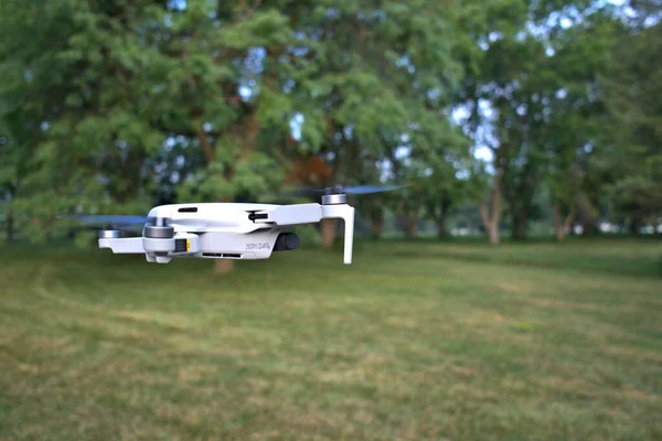 Közelkép Egy Dji Mini Drón Repülés Közben Fák Háttérben — Stock Fotó