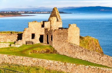 Ruin of Dunluce castle and Portrush in Northern Ireland clipart