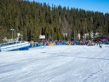 Bialka Tatrzanska, Polonya - 23 Şubat 2021: Güneşli bir havada kayakçıların ve snowboardcuların uzun bir günü
