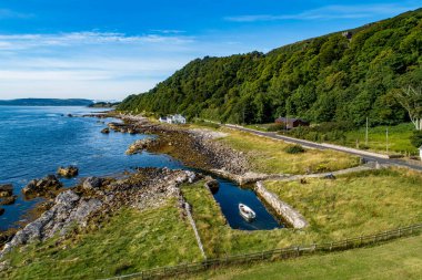 Kuzey İrlanda, İngiltere. Garron Point 'te Atlantik kıyısı. Causeway Sahil Yolu. Avrupa 'nın en manzaralı kıyı yollarından biri. Teknesi olan küçük bir marina. Hava görünümü.