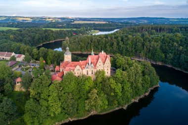 Polonya, Aşağı Silezya 'daki Czocha Ortaçağ Şatosu. 13. yüzyılda inşa edilmiş ve daha sonraları eklenmiş. Yazın hava manzarası, sabahın erken saatlerinde. Yapay Lesnianskie Gölü ve ormanlı Kwisa Nehri