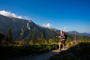 Tatry Dağları 'ndaki güzel manzaralı yakışıklı adam Giewont yolunda. Mavi gökyüzü ile güneşli güzel bir gün.