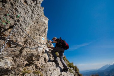 Giewont 'de yürüyüş yapan kıdemli bir adam. Tatry dağlarında güzel bir manzara. Mavi gökyüzüyle güneşli bir gün.