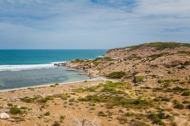 Vietnam 'da Phan Rang' dan Cam Ranh 'a motosiklet gezisi. Körfez çöp ve çöp dolu. Mui Ne 'nin kuzeyinde güneşli bir günde mavi gökyüzü manzarası.
