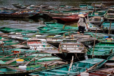 Vietnamlı konik şapkalı güzel manzara ve Ulusal Park Tam Coc 'ta tekneler, Vietnam' da Ninh Binh. Güneydoğu Asya 'da çekilmiş kırsal manzara fotoğrafı..